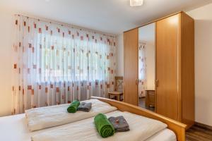 a bedroom with a bed with two green towels on it at Fuchsmichelhof 4 in Seebach