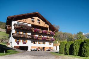 a building with balconies and flowers on it at Veltierhof Villnöß in Funes