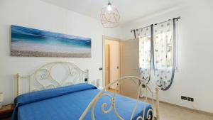 ein Schlafzimmer mit einem blauen Bett und einem Gemälde in der Unterkunft Casa Pullin in Carasco