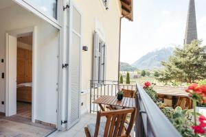 a balcony of a house with a table and chairs at Freienfeldhof Pink Lady in Lagundo +8 photos