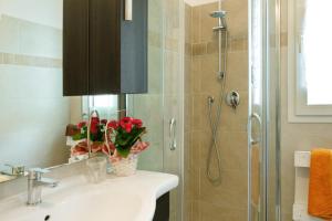 ein Badezimmer mit einem Waschbecken und einer Dusche mit Blumen darauf in der Unterkunft Casa Pullin in Carasco + 12 Fotos