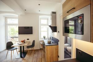 a small kitchen with a table and a bathroom at Freienfeldhof Pink Lady in Lagundo