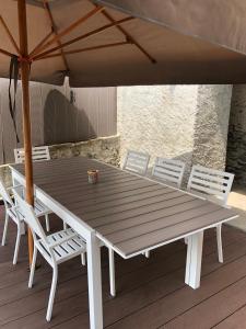 a wooden table with chairs and an umbrella on a deck at Villa Wetzel Domaso in Montemezzo