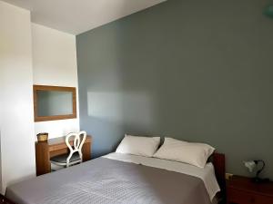 a bedroom with a bed and a desk and a chair at L'aia di San Giorgio in Ortelle