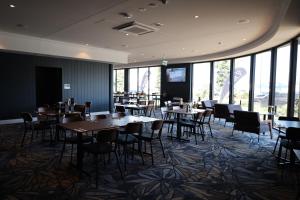 a dining room with tables and chairs and windows at Hotel Kingsley in Brisbane