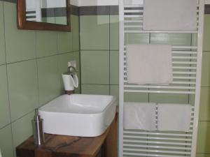 a bathroom with a sink and towels on a shelf at Damkröger 2 Inselwohnung - Seeblick in Lindau