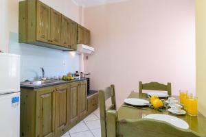 a kitchen with a table and a sink and a refrigerator at Apostolos Apartment 3 in Póndi +18 photos