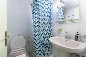 a bathroom with a white toilet and a sink at Apostolos Apartment 3 in Póndi