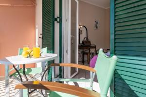 a table and chairs on a balcony with a table and drinks at Apostolos Apartment 3 in Póndi