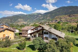 a house in a village with mountains in the background at Casa Lella Clemy in Aymavilles
