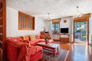 a living room with a red couch and a table at Casa Lella Clemy in Aymavilles