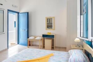 a living room with a blue door and a table at Studios Ninemia Serifos 2 in Livadi