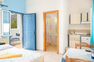 a room with a blue door and a kitchen at Studios Ninemia Serifos 2 in Livadi +13 photos