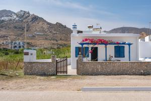 a small white house with a gate and flowers on it at Studios Ninemia Serifos 2 in Livadi