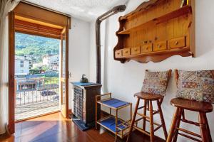 a living room with a stove and two stools at Casa Lella Clemy in Aymavilles