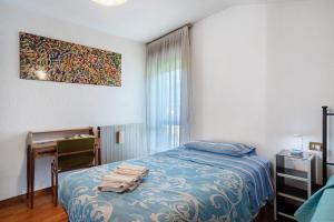 a bedroom with a bed and a desk and a window at Casa Lella Clemy in Aymavilles