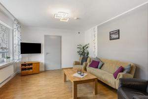 a living room with a couch and a tv at Ferienwohnung Christel in Schmallenberg