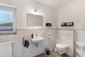 a white bathroom with a toilet and a sink at Ferienwohnung Christel in Schmallenberg +15 photos