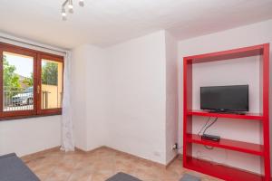 a living room with a tv on a red shelf at Appartamento del Pellicano in Olbia