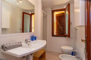 a white bathroom with a sink and a toilet at Appartamento del Pellicano in Olbia +16 photos