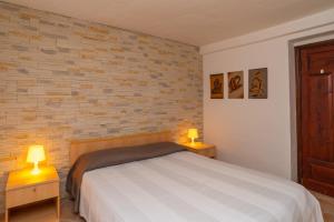 a bedroom with a bed and two tables with lamps at Appartamento del Pellicano in Olbia