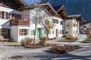 a house in a village with mountains in the background at Ferienwohnung Bernstein in Mittenwald