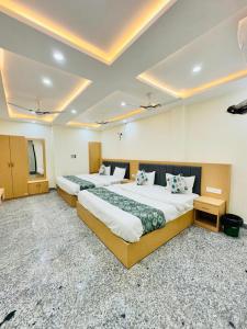 a hotel room with two beds in a room at HOTEL SHIVAAY near by urban Square mall and nexus celebration mall in Bedla +15 photos