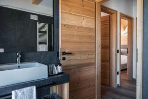 a bathroom with a sink and a mirror at Arnica Alpin Lodge in Cavedago +27 photos