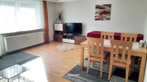 a living room with a dining room table and a television at Haus Broni in Prem