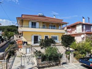 a yellow house with a balcony on a street at Panorama House Petritis in Petrití