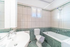 a bathroom with a toilet and a tub and a sink at Panorama House Petritis in Petrití +18 photos