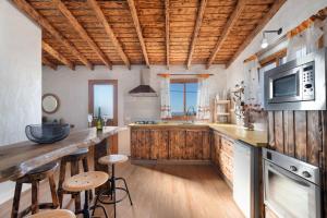 a kitchen with wooden cabinets and a counter with stools at El Rincón de Yeico in Isora