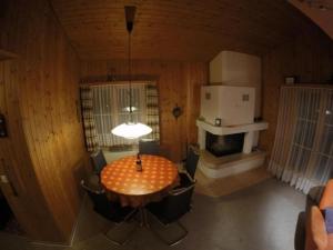a dining room with a table and chairs and a refrigerator at Apartment Chalet Steinbock by Interhome in Lenk