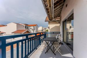 a balcony with a table and chairs on a building at Loft familial Arcachon in Arcachon