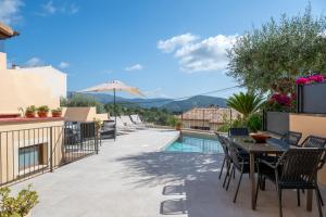 a patio with a table and chairs next to a pool at Can Vidal in Campanet