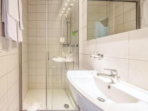 a white bathroom with a sink and a shower at Apartment Hirschen Erlinsbach by Interhome in Erlinsbach