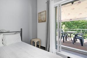 a bedroom with a bed and a balcony with a table at Iguana studio 9 in Preveza