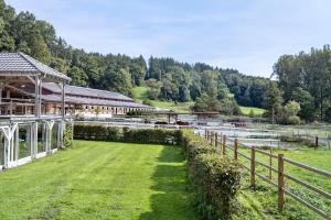 a building with a fence next to a grass field at Chalets Jettweiler in Stockach