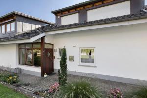 a white house with a brown door at Rinderle in Stockach