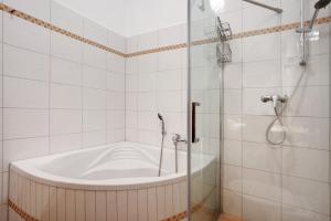 a bathroom with a bath tub and a shower at Traumschlößchen 100 m vom Strand in Heringsdorf +21 photos