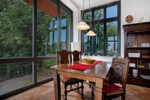 a dining room with a table with chairs and large windows at Traumschlößchen 100 m vom Strand in Heringsdorf