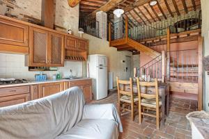a kitchen with a table and a white refrigerator at Villa Chelucci - Gualdo in Massarosa