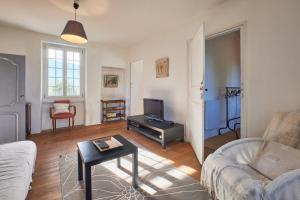 a living room with a couch and a tv at Location Au Pied Du Vercors in Vinay