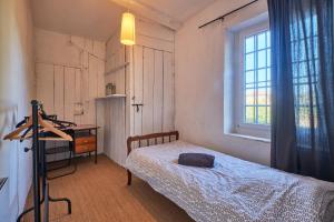 a bedroom with a bed and a desk and a window at Location Au Pied Du Vercors in Vinay