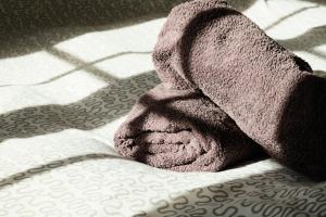 a towel sitting on top of a bed at Location Au Pied Du Vercors in Vinay +15 photos