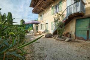 a courtyard of a building with a table and an umbrella at Location Au Pied Du Vercors in Vinay