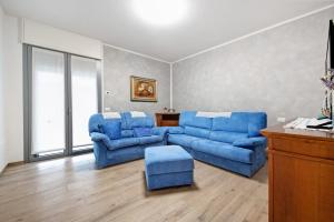 a living room with two blue chairs and a couch at Casa Tovini in Pisogne