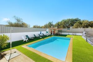 a backyard with a swimming pool and grass at Villa As Cumadres in Azeitao