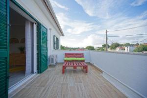 a bench sitting on the balcony of a house at Villa As Cumadres in Azeitao