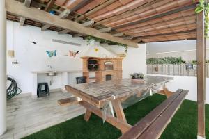a dining room with a wooden table and a fireplace at Villa As Cumadres in Azeitao
